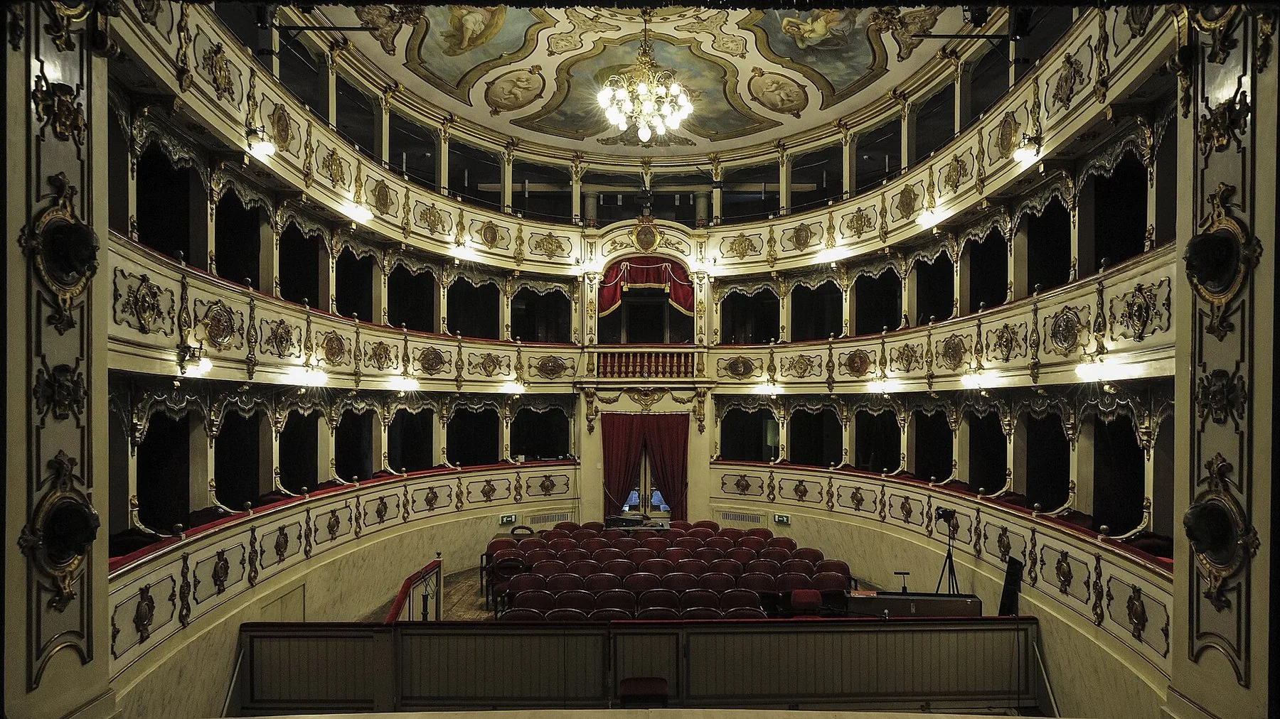 Salen i Teatro Verdi i Busseto, med tre etasjer losjer i hvitt og gull, røde seter og en lysekrone under det malte taket.