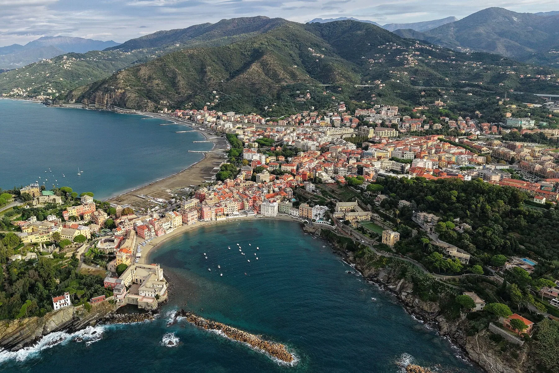 Sestri Levante sett fra luften, med halvøya mellom to bukter, strender på begge sider og grønne åser bak byen.