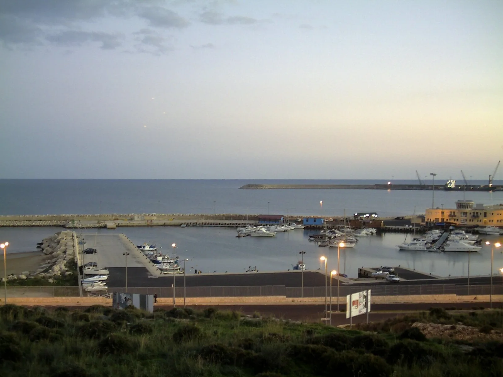 Havnen i Pozzallo på Sør-Sicilia med moloer, småbåter og fergekaia ute ved havet.
